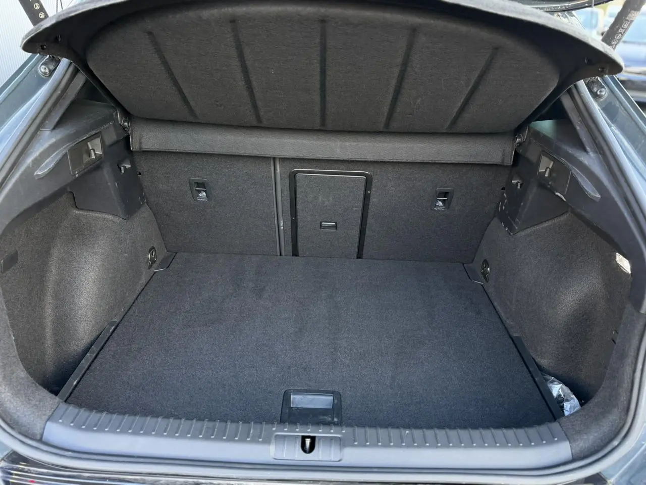 Coffre ouvert vu de l'arrière d'un CUPRA Formentor Bleu Fjord, espace de chargement vide et doublure noire.