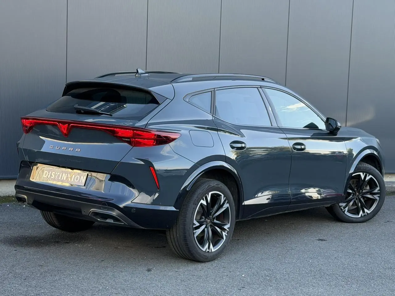 Vue 3/4 arrière droite du CUPRA Formentor bleu Fjord avec feux arrière Tri-LED et jantes alliage noires.