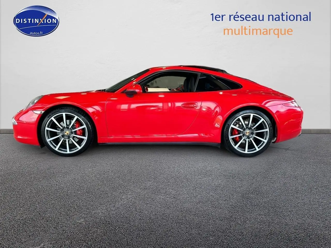 Profil droit d'une Porsche 911 (991) Carrera 4 PDK rouge avec jantes alu et toit ouvrant électrique.