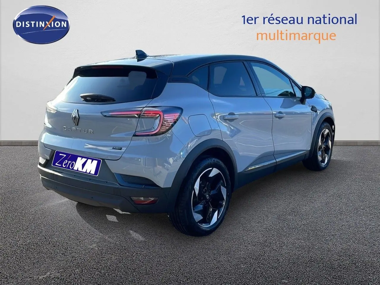 Vue 3/4 arrière droite d'un Renault Captur gris Rafale métal avec toit noir et jantes biton sur fond neutre.