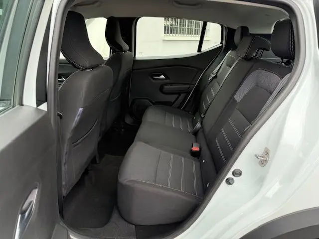 Vue intérieure côté gauche montrant les sièges arrière noirs du Dacia Sandero Stepway blanc 2021.