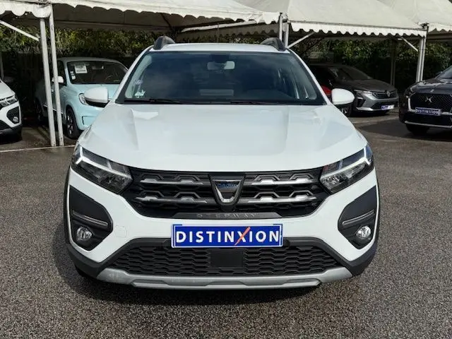 Vue frontale d'une Dacia Sandero Stepway blanche 2021 avec calandre noire et logo distinctif au centre.