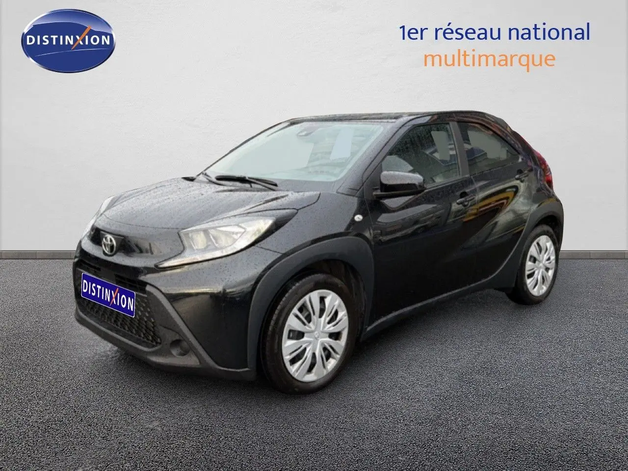 Toyota Aygo X noir vue 3/4 avant droit, compacte avec jantes argentées et calandre marquée.