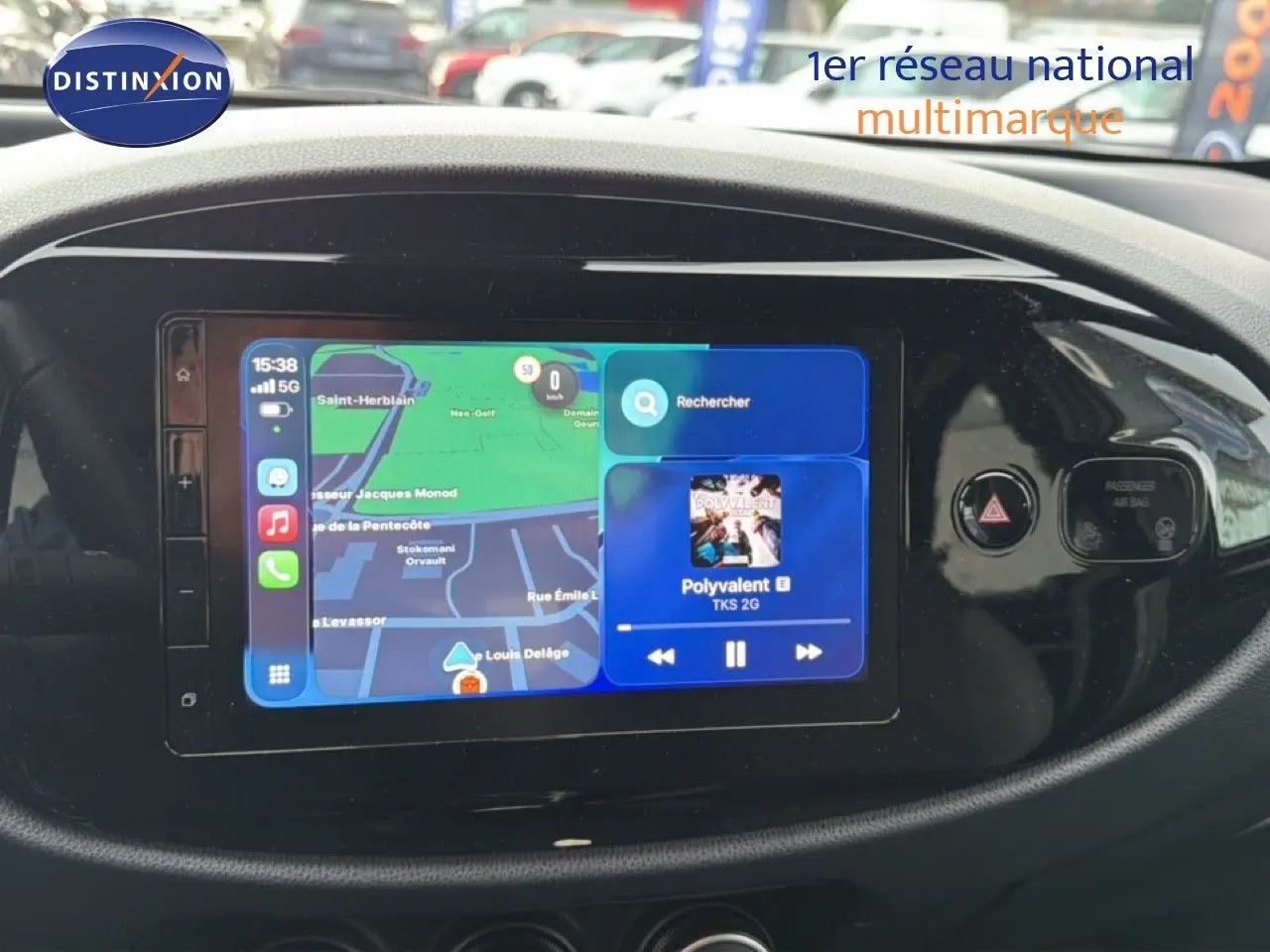 Écran tactile central de la Toyota Aygo X 2025 affichant navigation et musique, entouré de commandes noires brillantes.