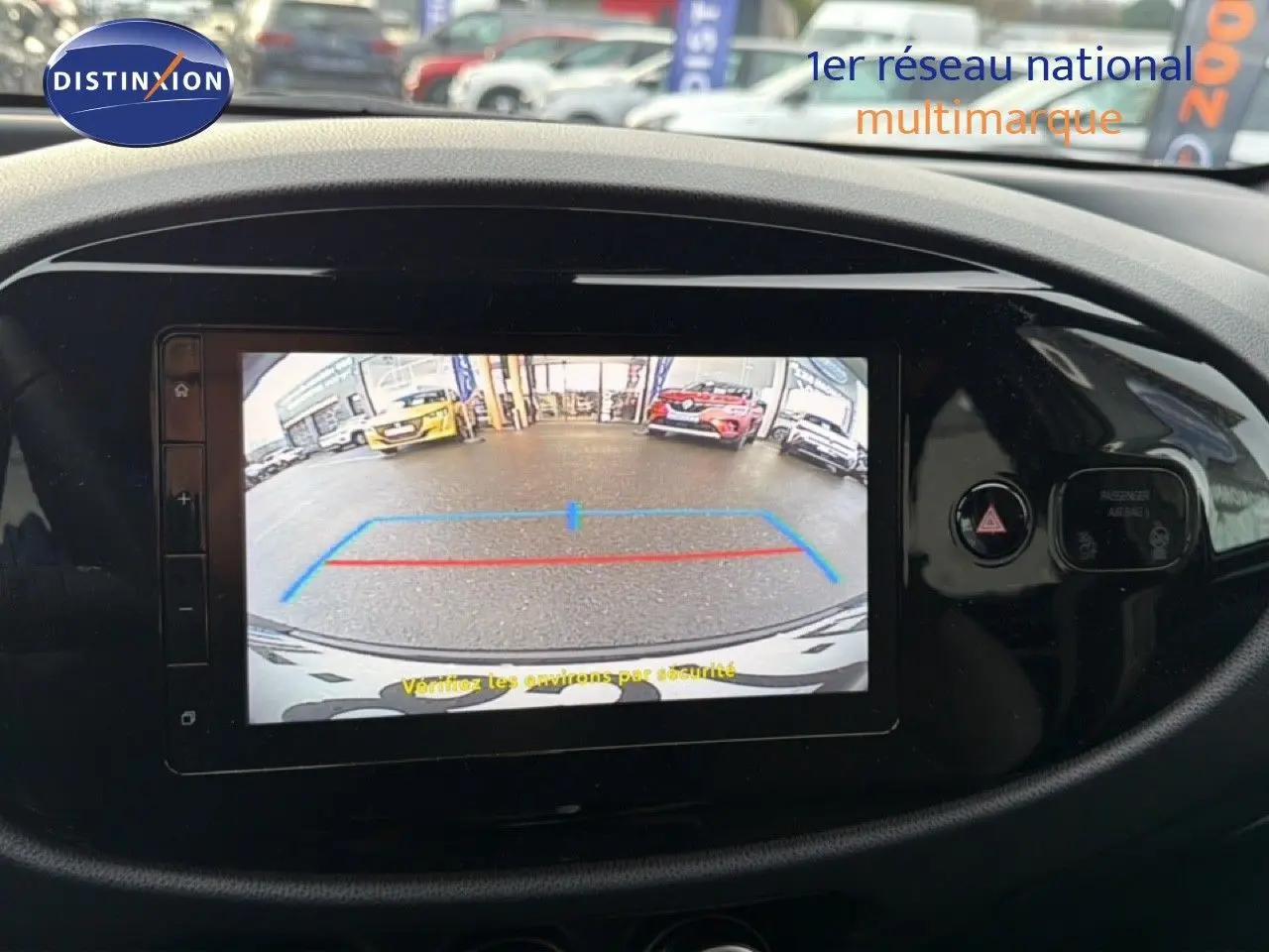 Écran central de la Toyota Aygo X 2025 montrant la caméra de recul avec repères colorés sur fond noir brillant.