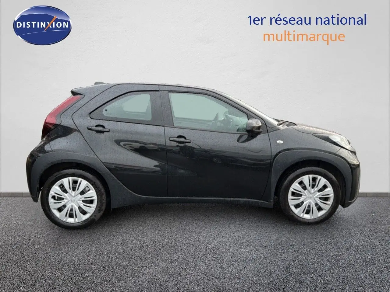 Profil côté gauche de la Toyota Aygo X noire 2025, compacte et moderne avec cinq portes visibles.