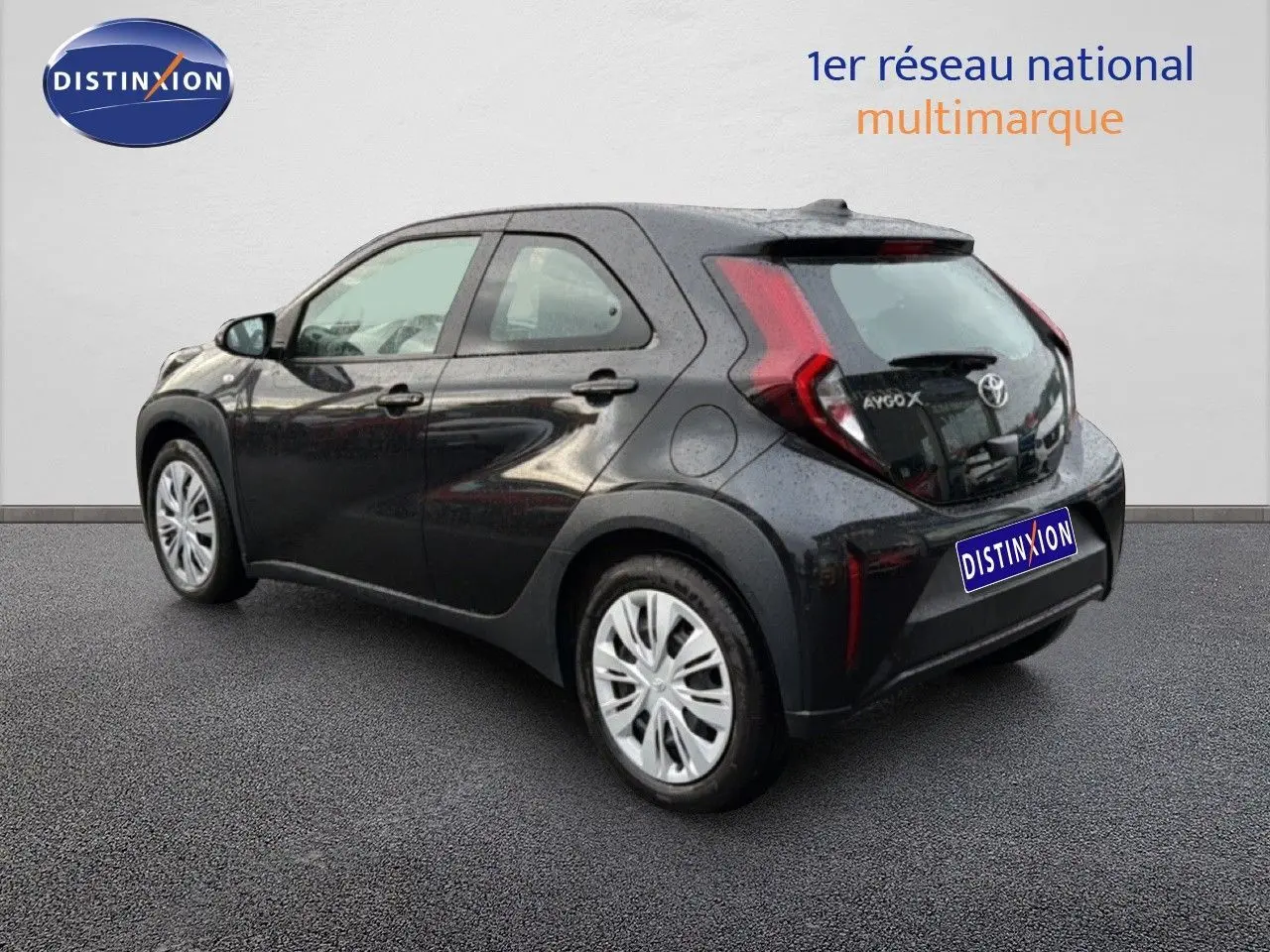 Vue 3/4 arrière droite d'une Toyota Aygo X noire 2025, compacte avec feux arrière en forme de boomerang.