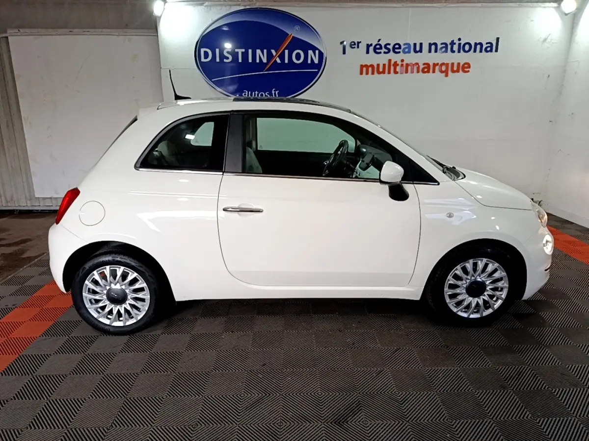 Profil droit d'une FIAT 500 blanche 2021, compacte et élégante, avec jantes alliage et rétroviseurs assortis.