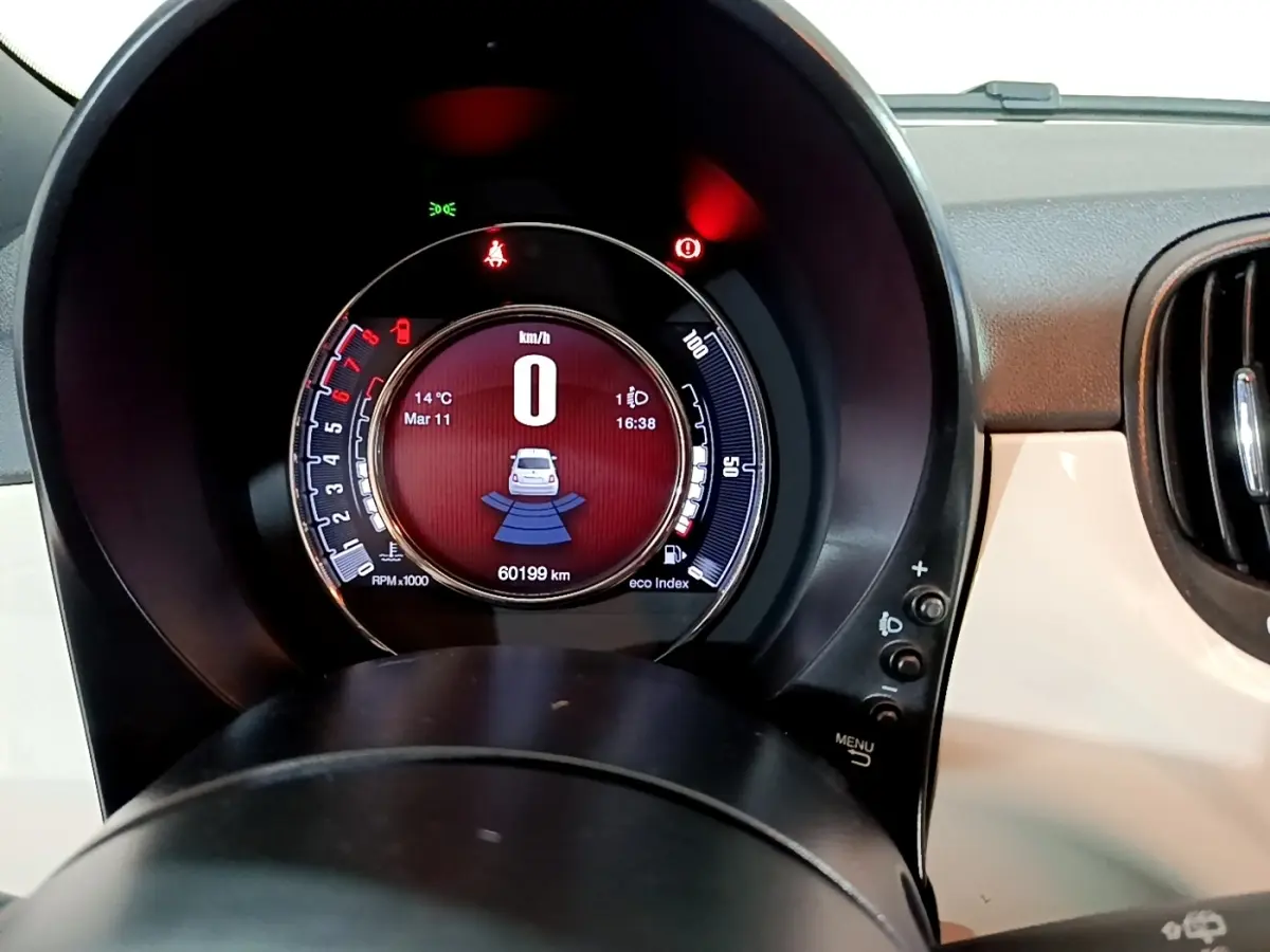 Vue rapprochée du tableau de bord numérique de la Fiat 500 blanche, affichant 0 km/h et 60199 km au compteur.
