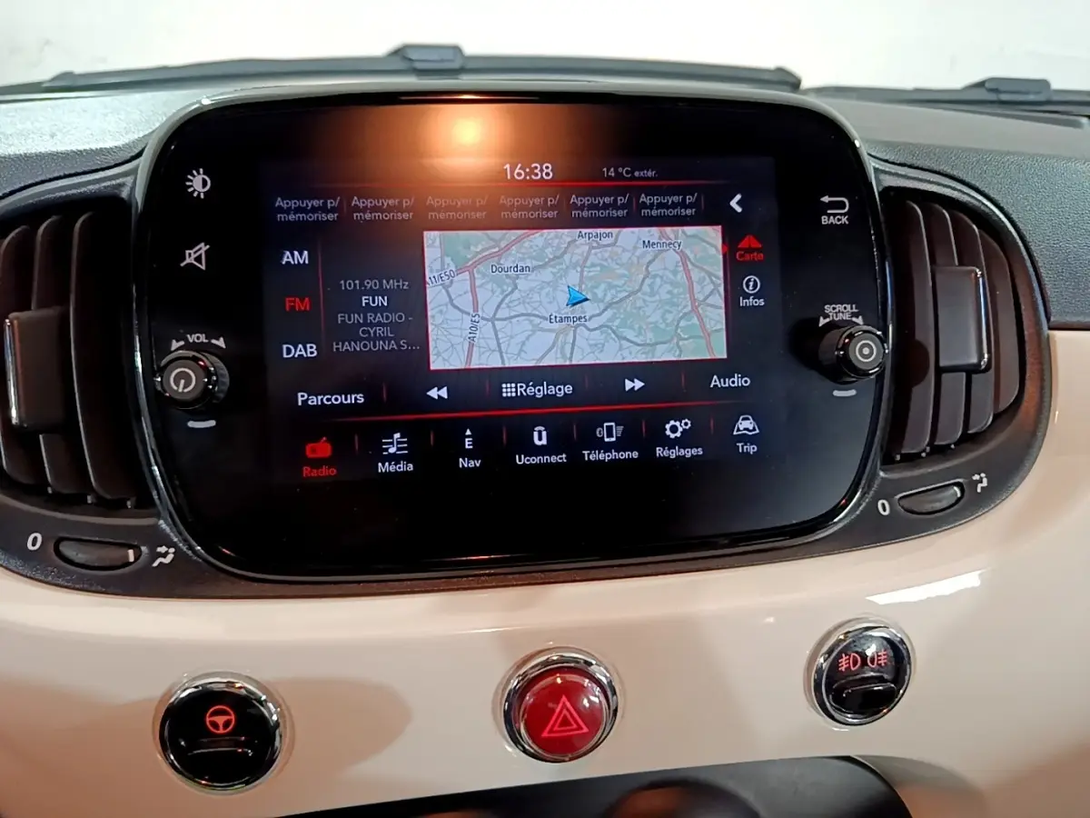 Écran tactile central avec navigation affichée sur tableau de bord beige de Fiat 500 Hybrid blanc, vue intérieure frontale.