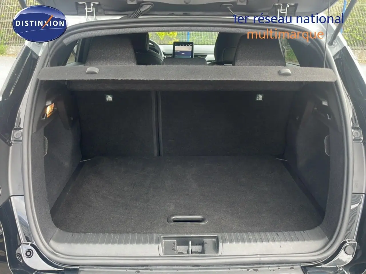 Coffre ouvert vu de l'arrière d'un Renault Captur noir étoile métal avec toit gris, montrant l'espace de chargement vide.