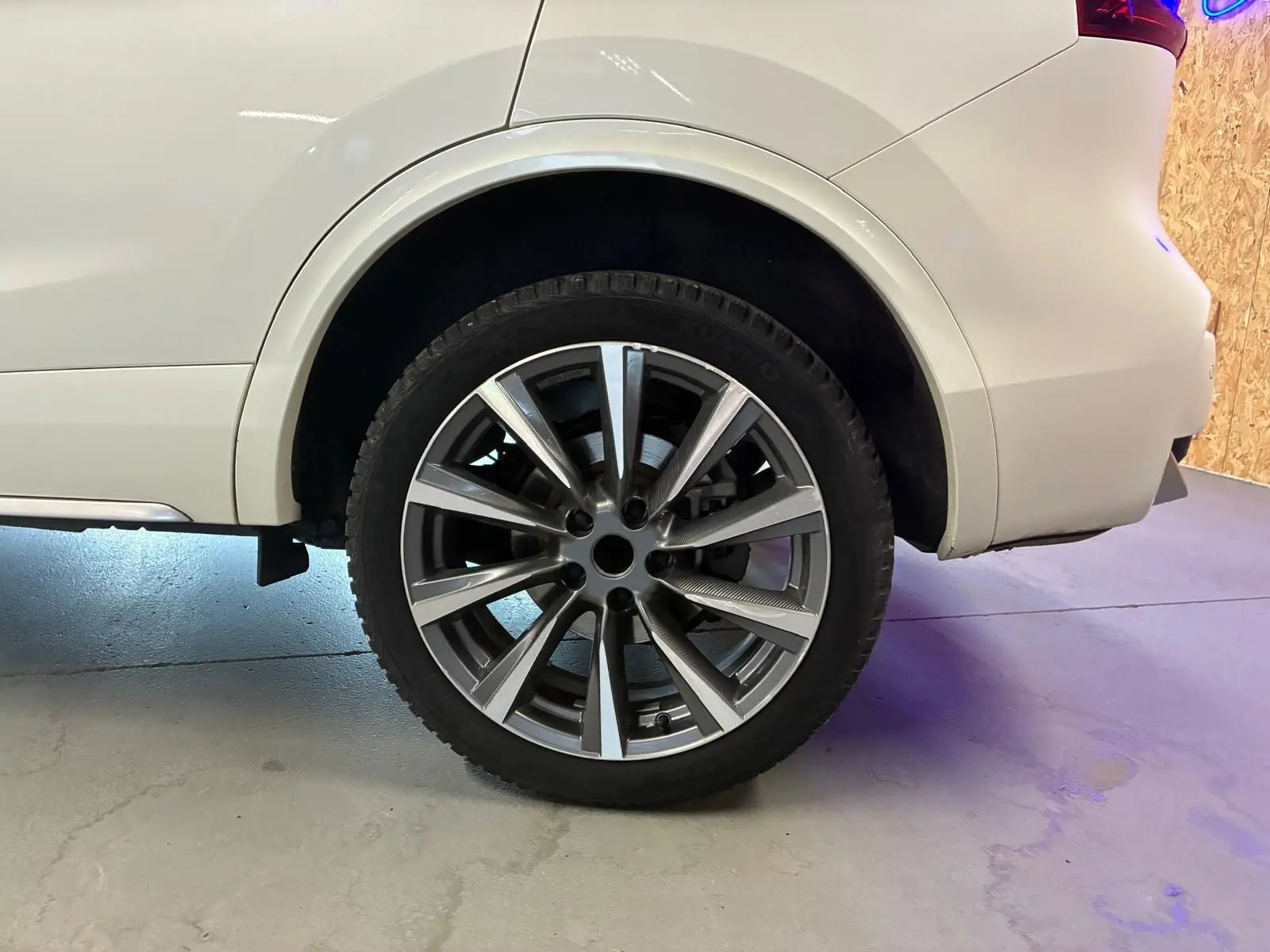 Gros plan sur la roue arrière droite du Nissan Qashqai blanc, mettant en valeur la jante alliage moderne.