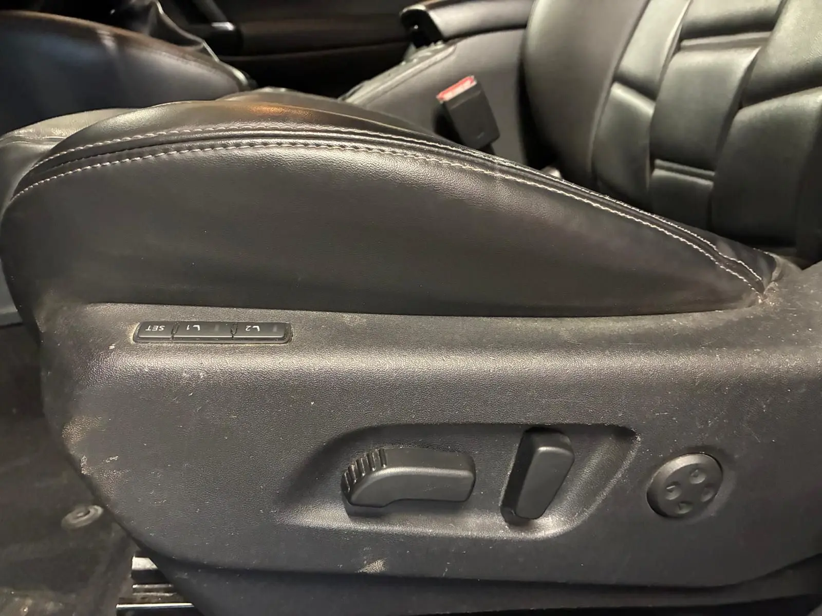 Gros plan sur les commandes de réglage électrique du siège en cuir noir du Nissan Qashqai 1.5 BlueDCI Tekna+ 2021.