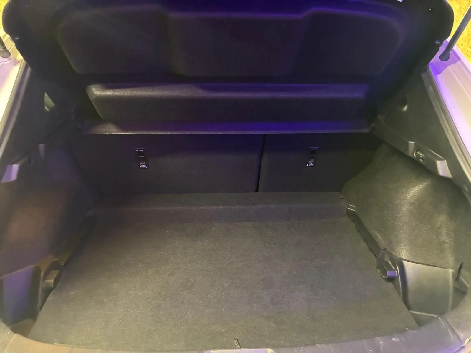 Coffre ouvert du Nissan Qashqai blanc 2021, vue intérieure montrant l'espace de chargement vide et le cache-bagages relevé.