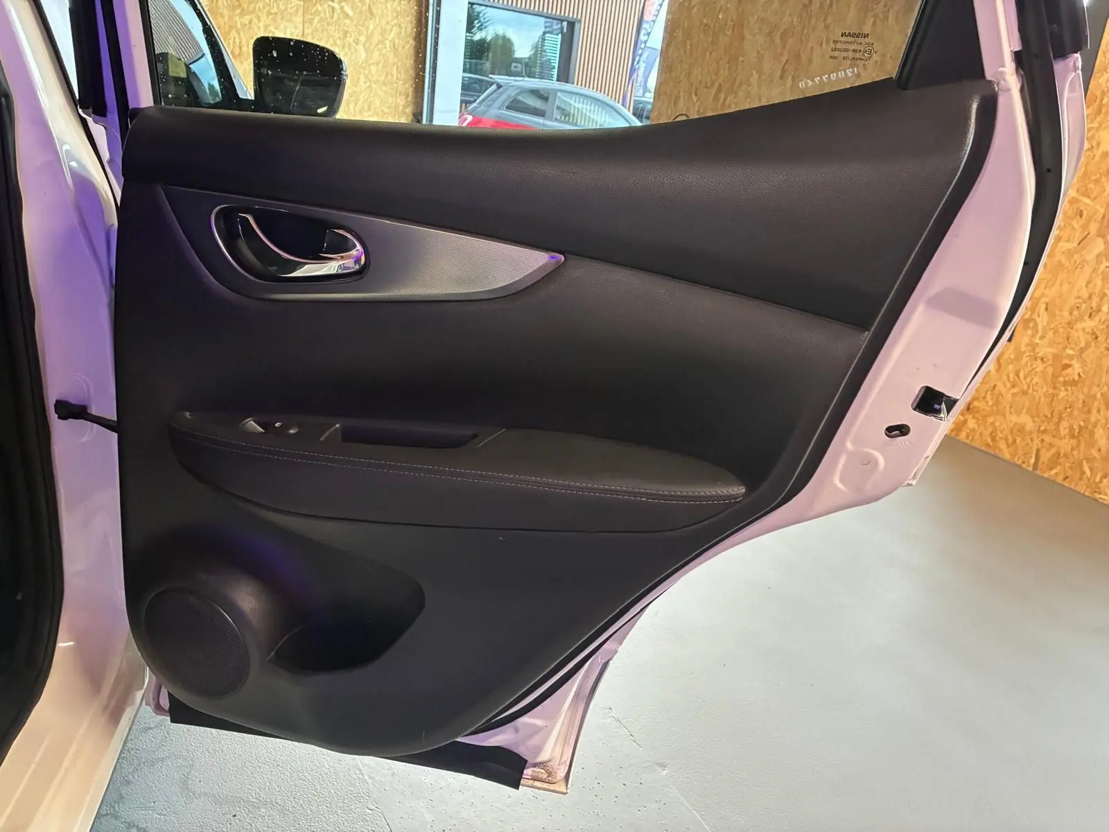 Vue intérieure de la porte arrière droite du Nissan Qashqai blanc 2021, avec garniture noire et poignée chromée.