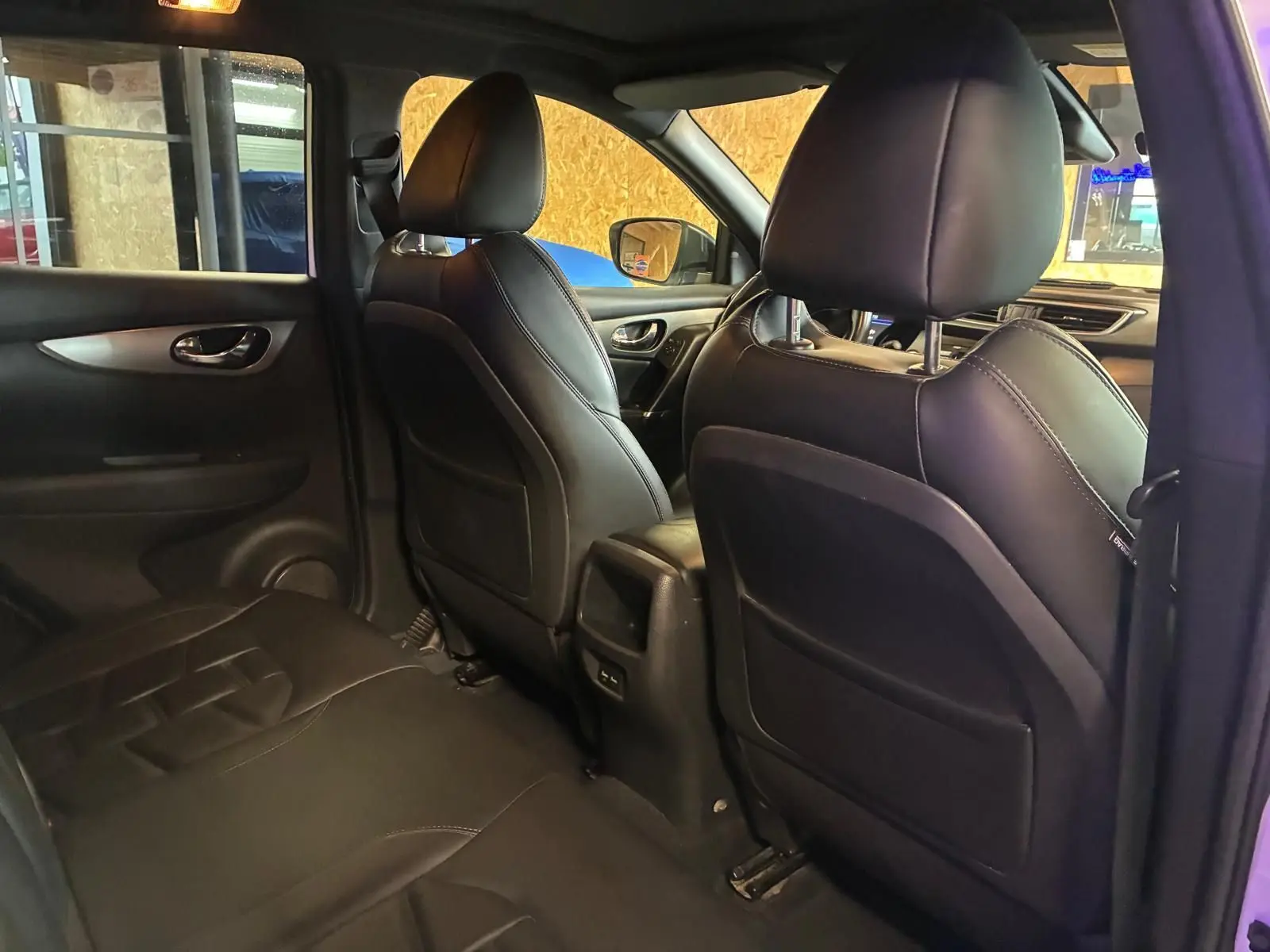 Vue intérieure arrière côté droit du Nissan Qashqai 1.5 BlueDCI 115 Tekna+ 2021 avec sièges en cuir noir et finitions modernes.