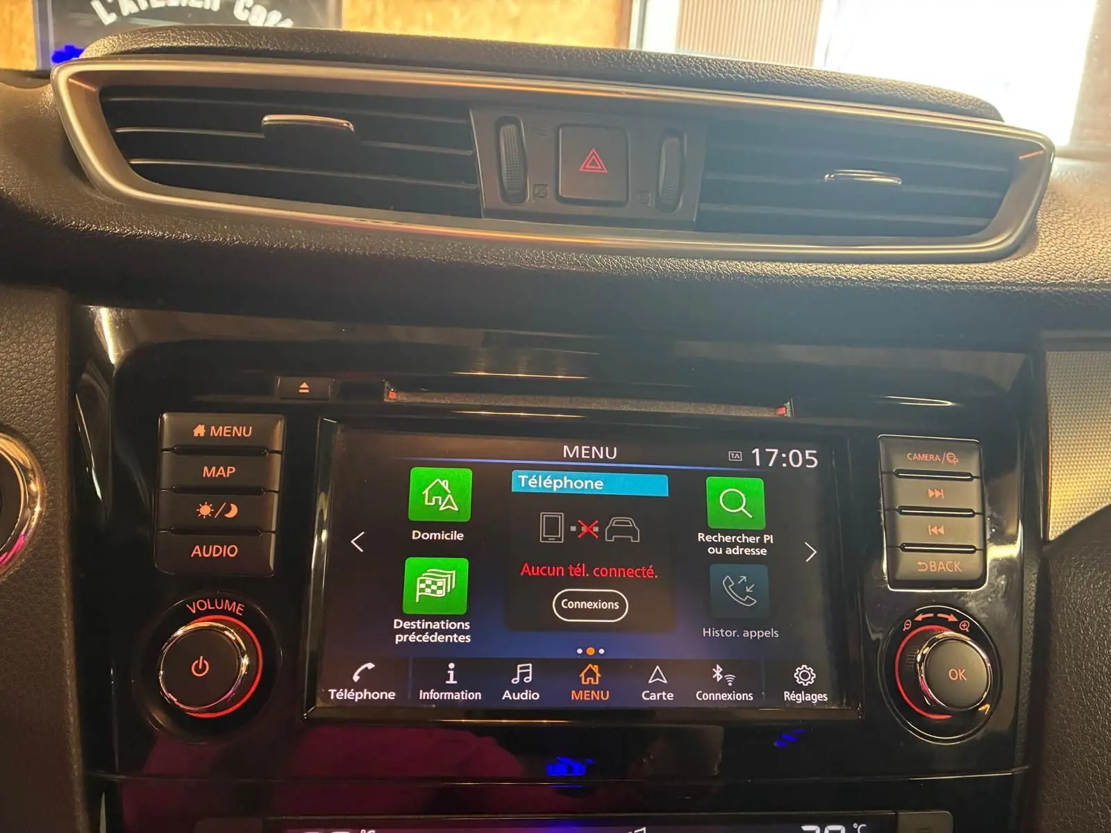 Vue rapprochée de la console centrale noire du Nissan Qashqai 1.5 BluedCi 115 Tekna+ avec écran tactile et commandes lumineuses.