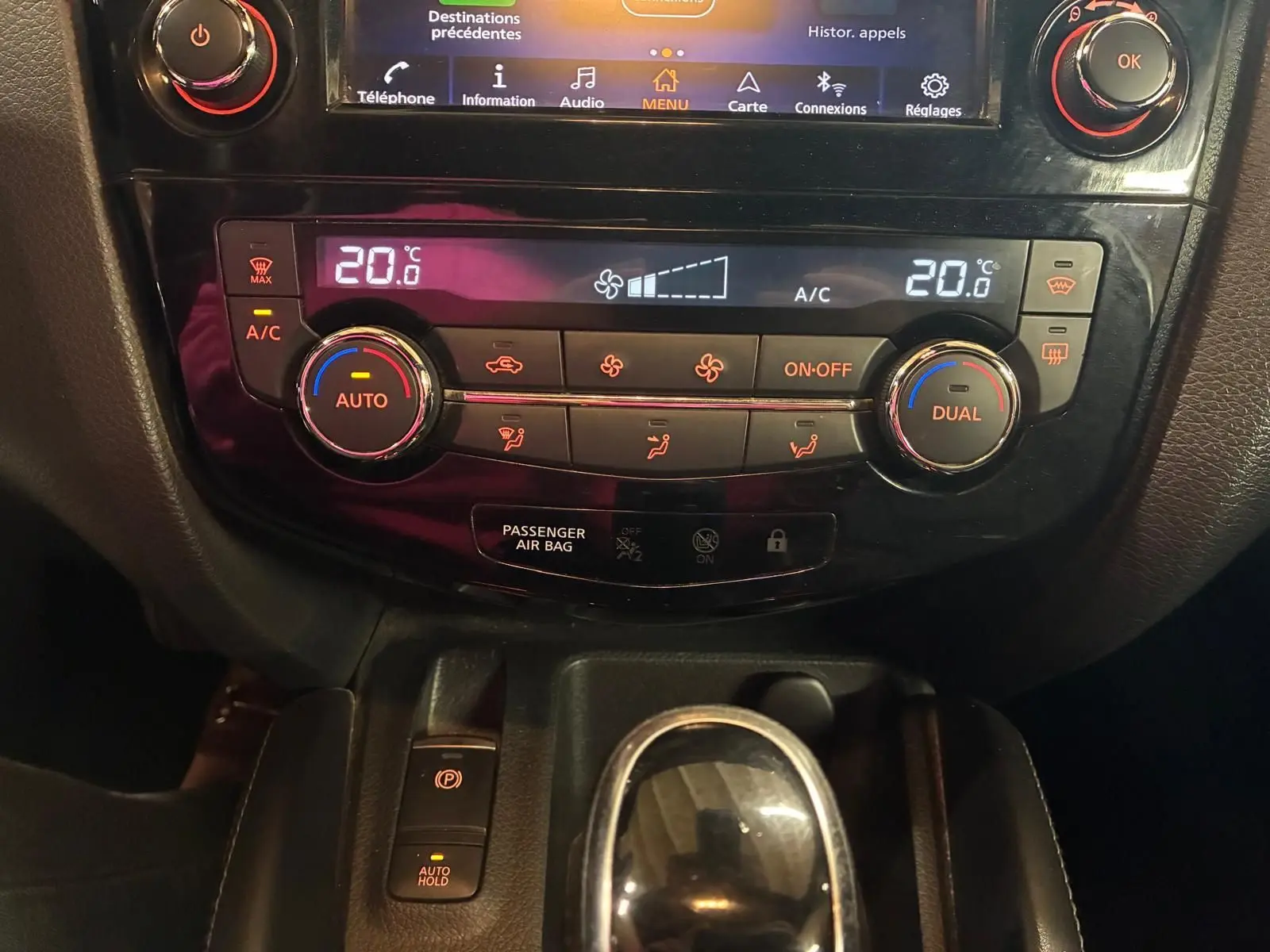 Vue rapprochée du tableau de bord du Nissan Qashqai 1.5 BlueDCI 115 Tekna+ 2021, avec commandes climatisation et boîte auto.