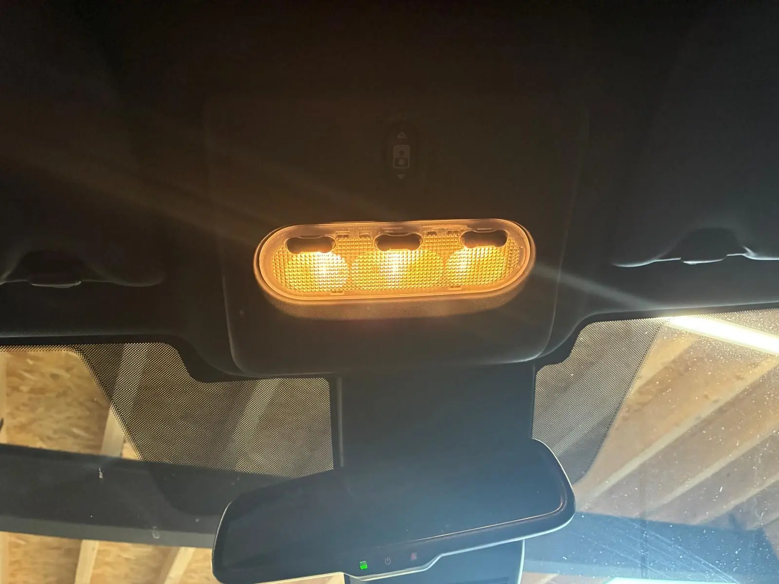 Plafonnier intérieur allumé vu de face dans un Nissan Qashqai blanc 2021, avec rétroviseur central et pare-brise partiellement visible.
