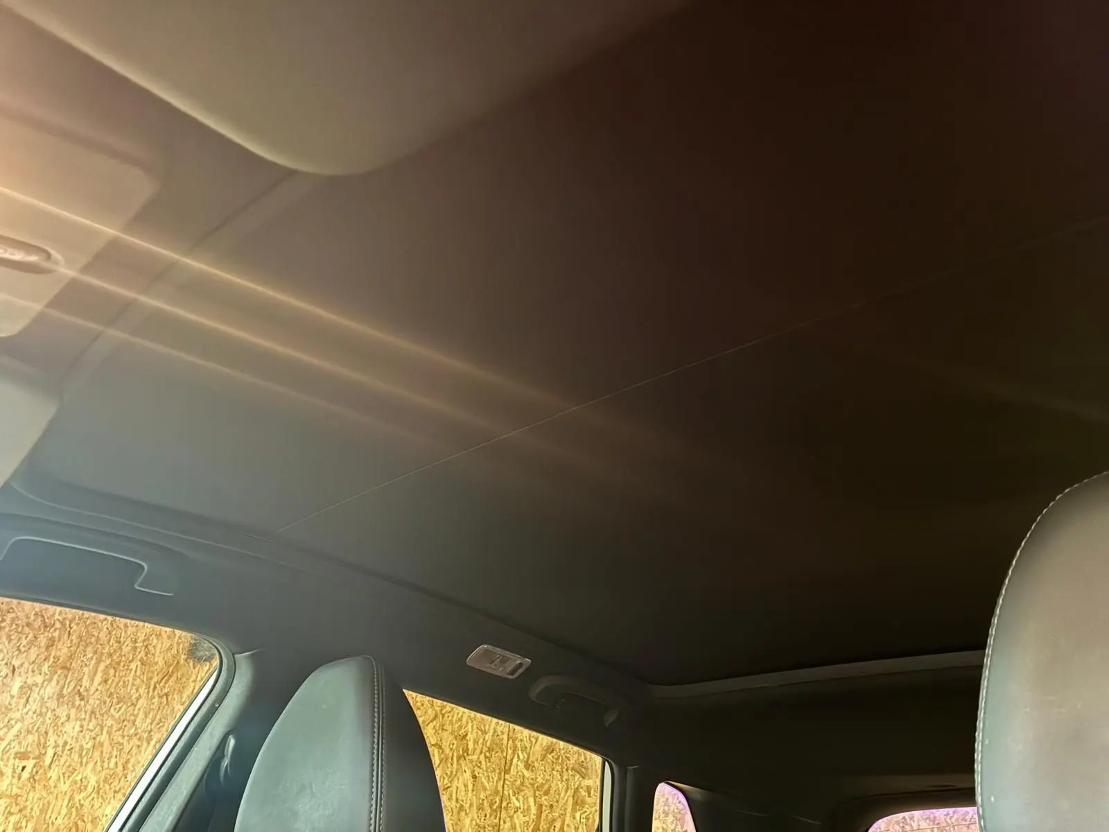 Vue intérieure du toit panoramique et des appuie-têtes avant en cuir noir du Nissan Qashqai blanc 2021.
