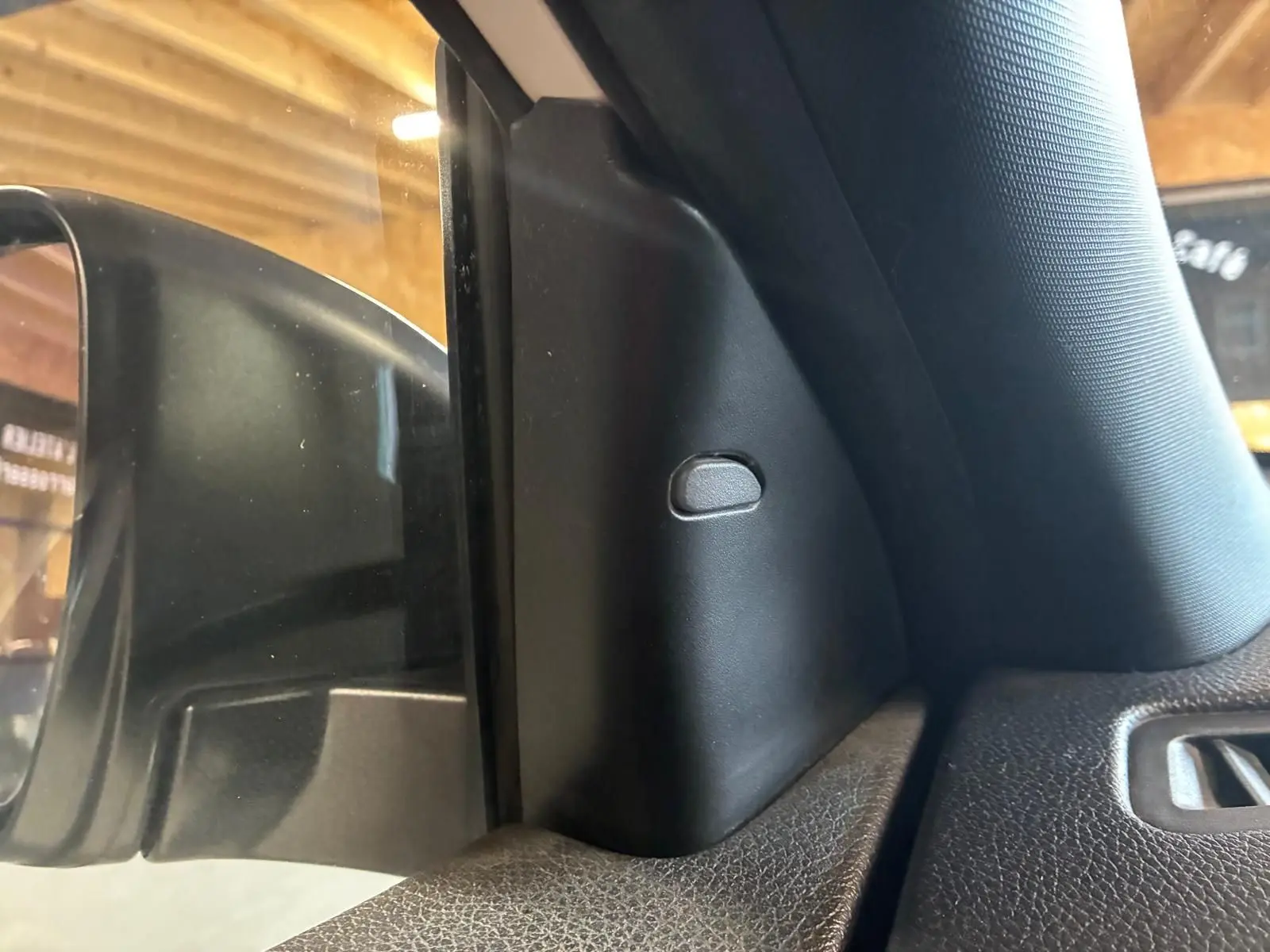 Détail intérieur montrant la garniture noire côté gauche près du rétroviseur d’un Nissan Qashqai blanc 2021.