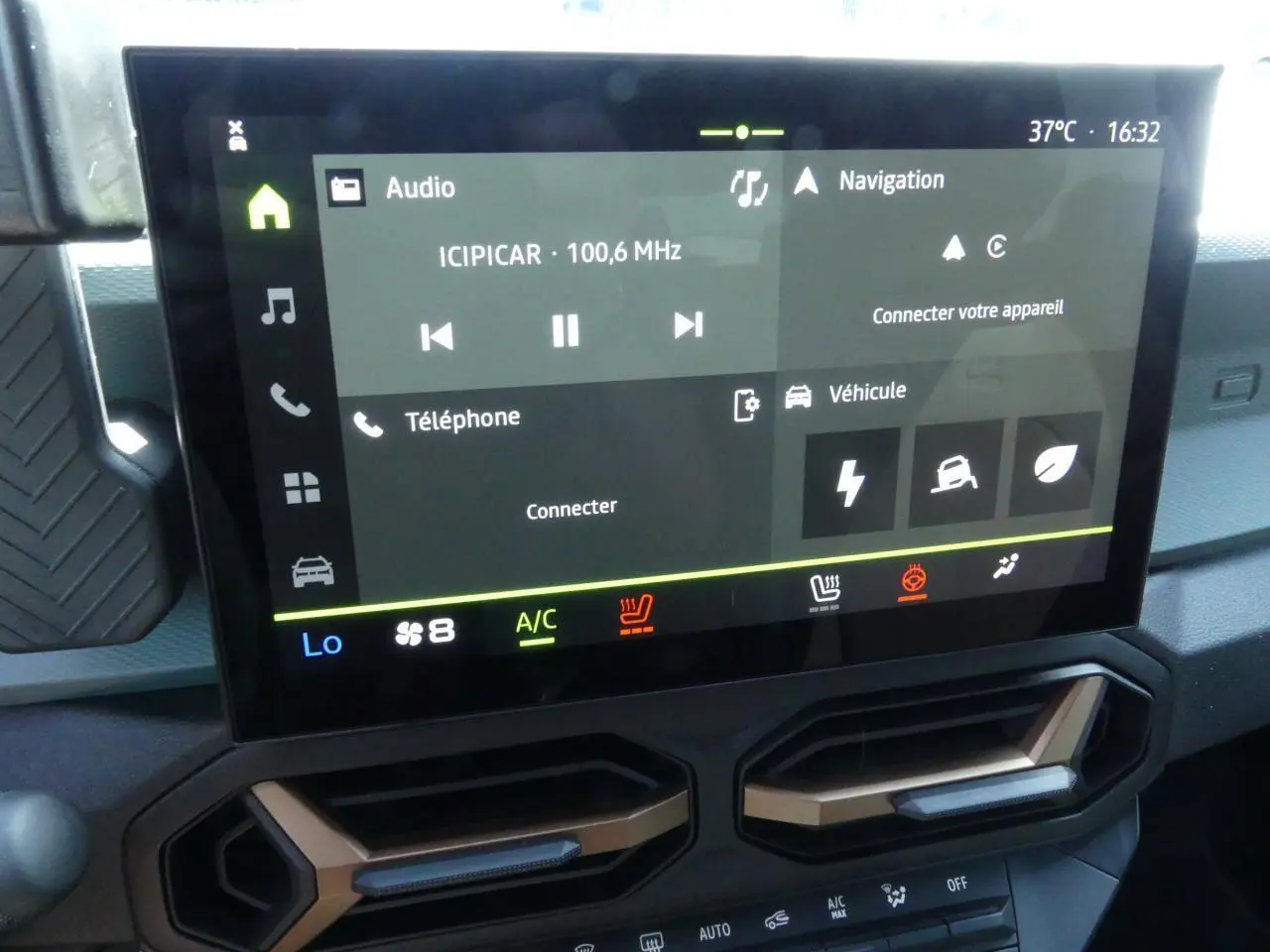 Écran tactile 10 pouces du tableau de bord du Dacia Duster 1.6 Hybrid 2025 avec aérateurs brun cuivré.