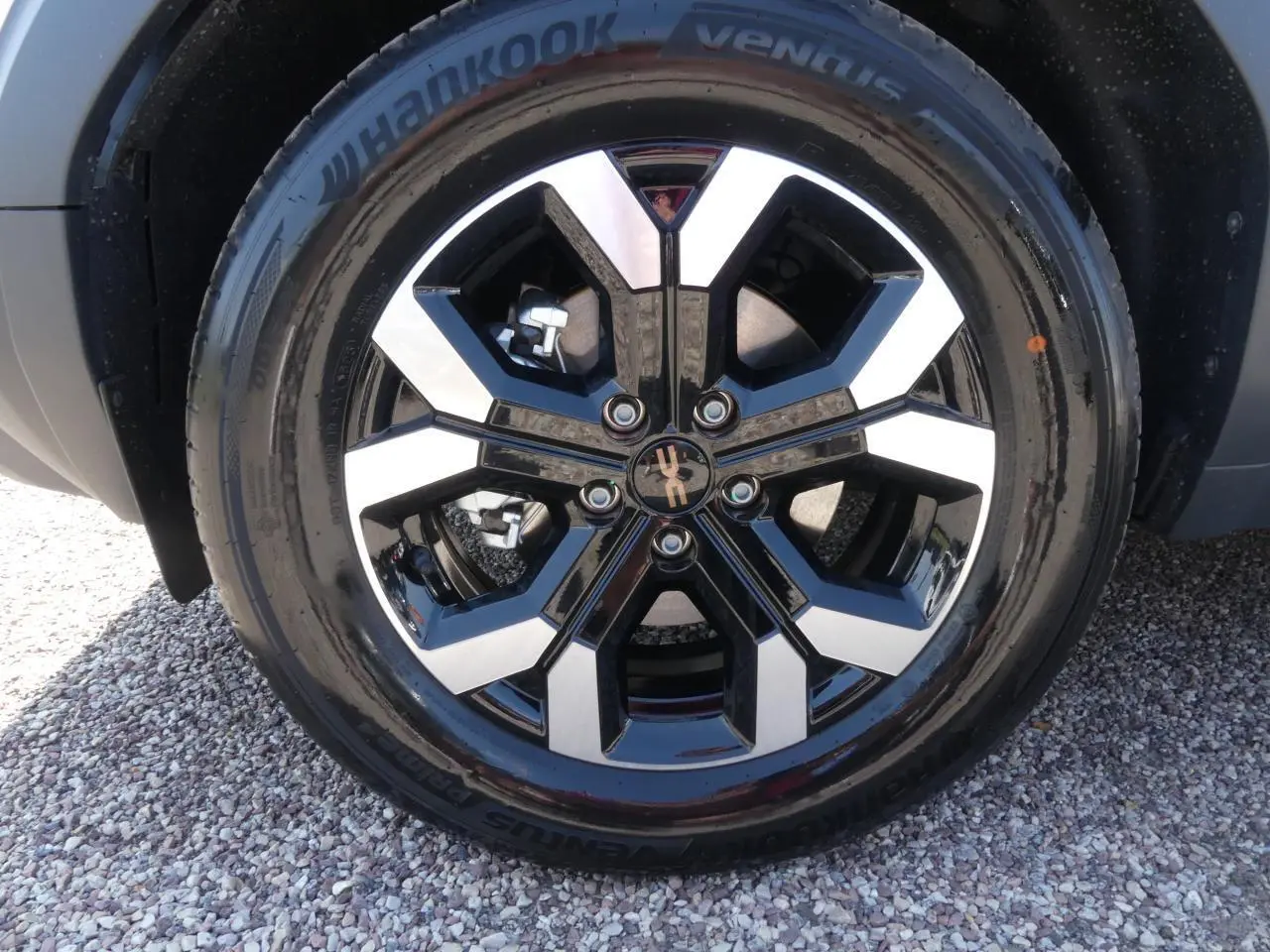 Gros plan sur la jante alliage 17 pouces bicolore noir et argent du Dacia Duster blanc Glacier 2025.