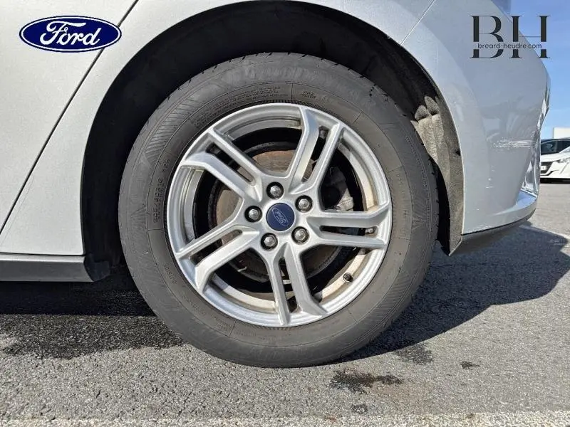 Gros plan sur la roue avant droite d'une Ford Focus 2020 gris lunaire métallisé avec jante alu à 5 branches doubles.