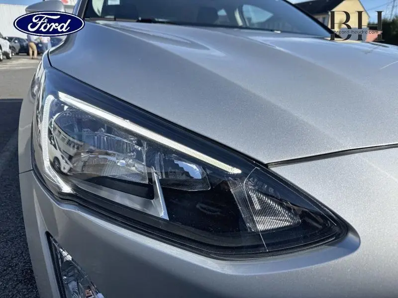 Gros plan sur le phare avant droit de la Ford Focus 1.5 EcoBlue gris lunaire métallisé, soulignant ses lignes modernes.