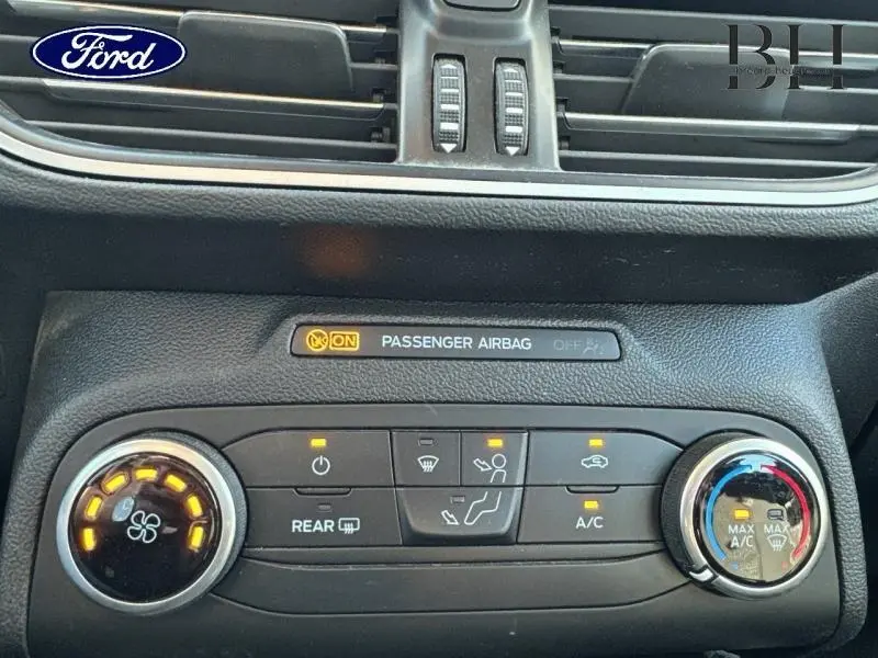 Gros plan sur la console centrale de la Ford Focus 2020 gris lunaire, avec commandes climatisation et indicateur airbag passager.