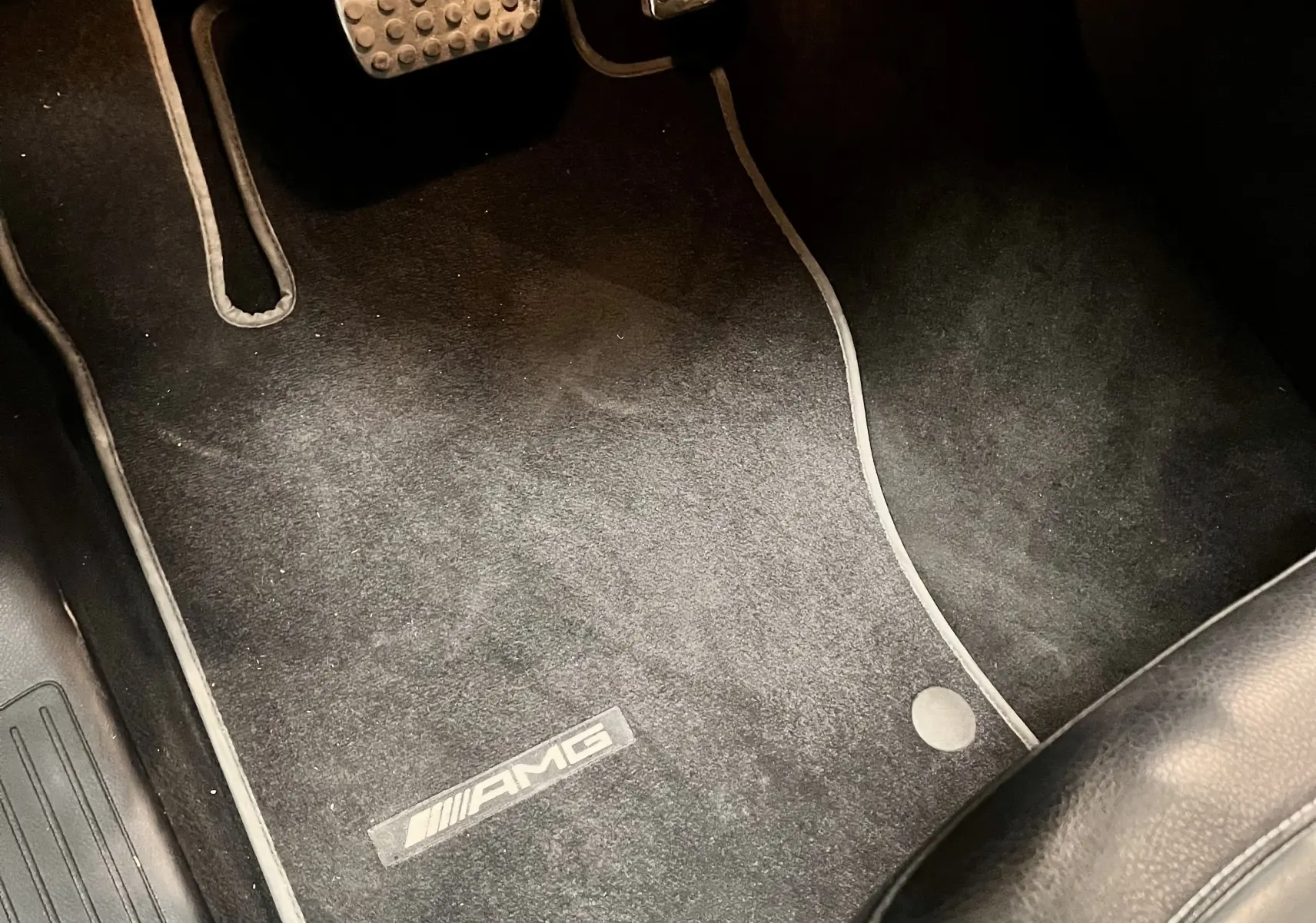 Gros plan sur le tapis de sol noir AMG et les pédales en métal du côté conducteur du Mercedes GLE Coupe 350 d 2016.