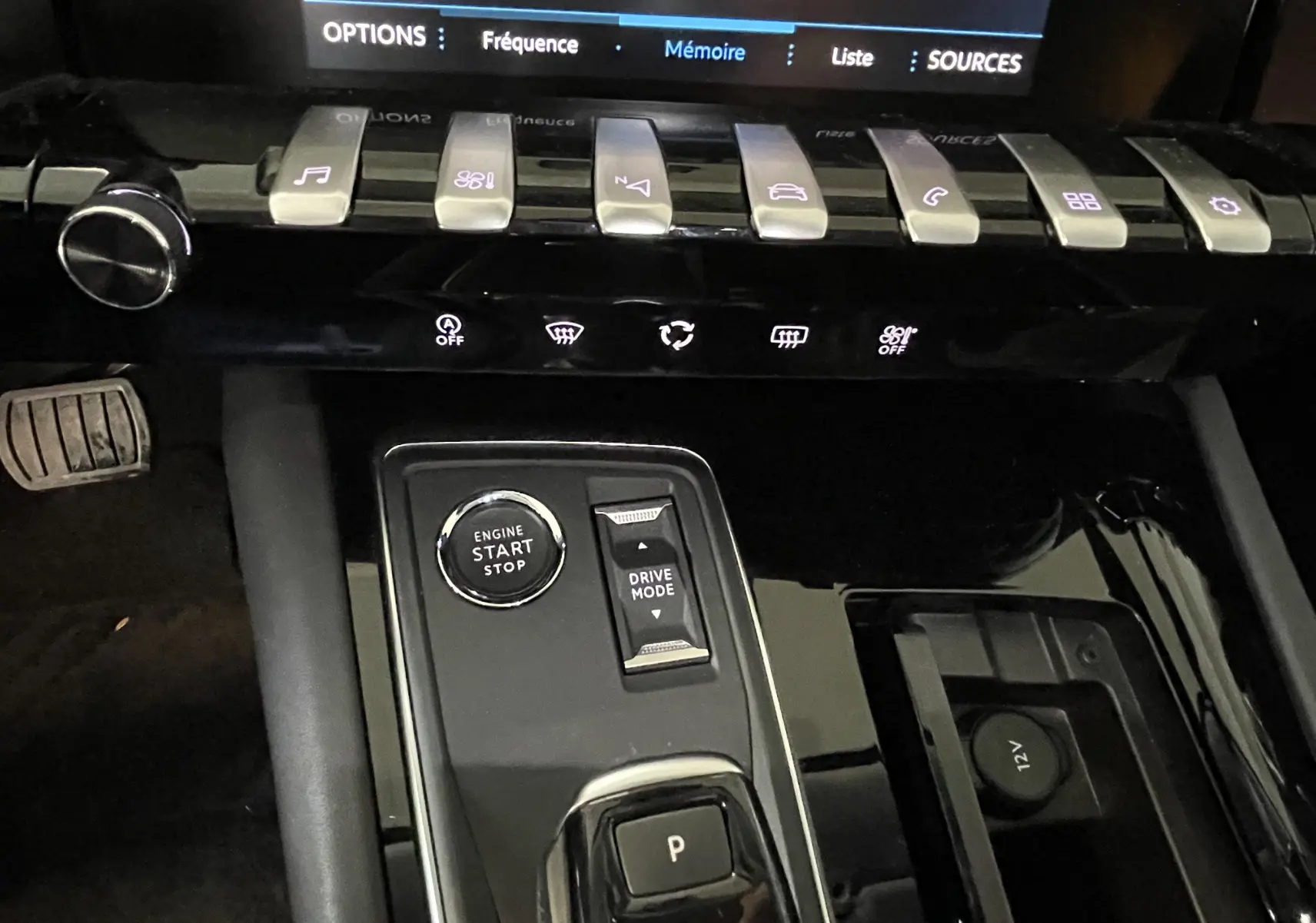 Gros plan sur la console centrale noire brillante du Peugeot 508 gris platinium, avec bouton start/stop et commandes de mode de conduite.