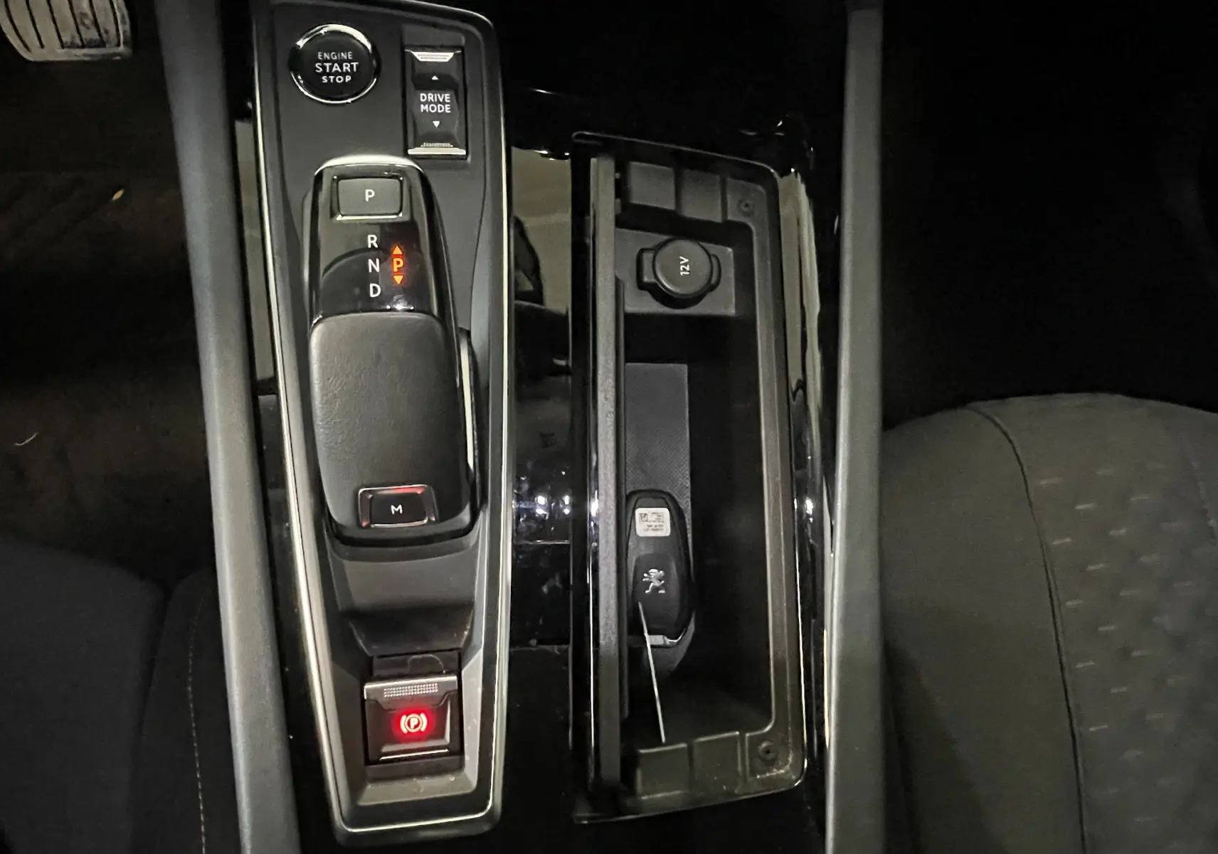 Vue rapprochée de la console centrale noire du Peugeot 508 gris platinium, avec levier de vitesses automatique et bouton start/stop.