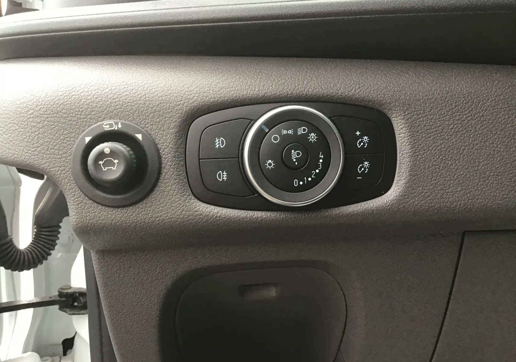 Gros plan sur les commandes d'éclairage du tableau de bord du Ford Transit Chassis Cabine blanc 2024.