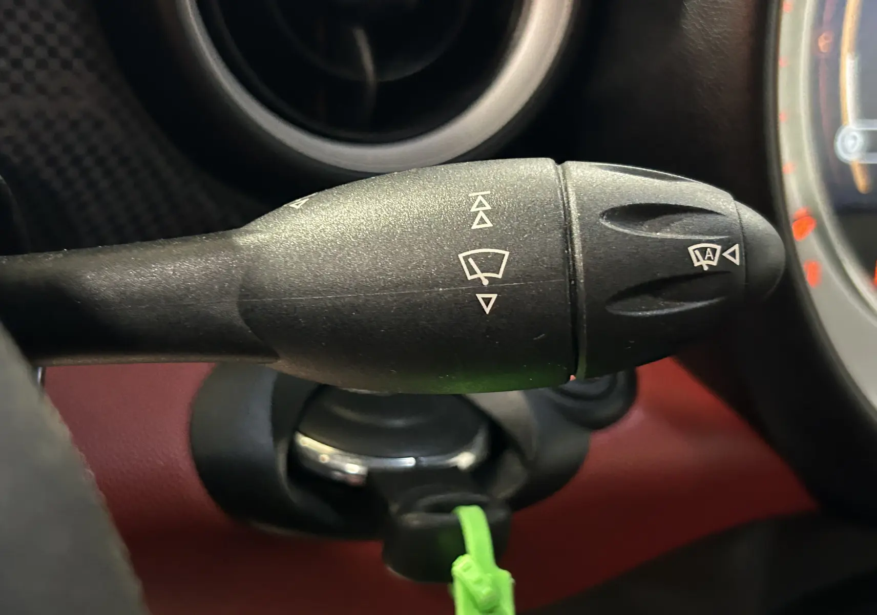 Gros plan sur la commande des feux et clignotants dans l'habitacle rouge d'une MINI Cabriolet Cooper S 2012.