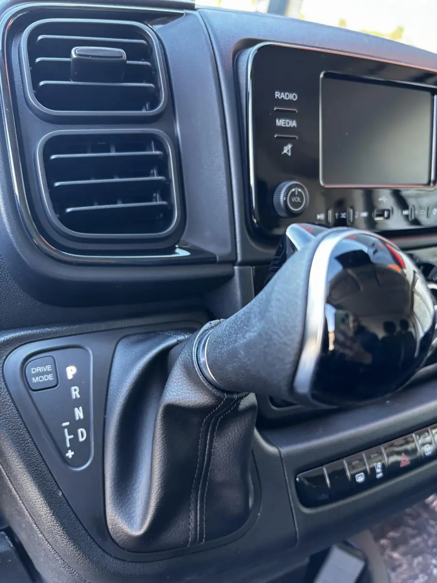 Gros plan sur le levier de vitesses automatique et la console centrale noire du Peugeot Boxer Fourgon blanc, version 2025.
