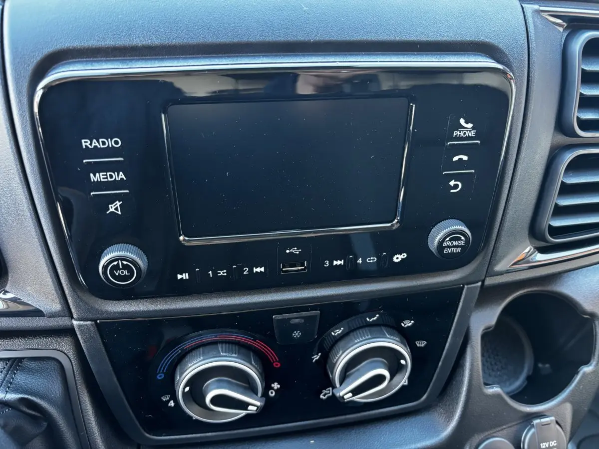 Tableau de bord du Peugeot Boxer Fourgon 2025 montrant l'écran tactile et les commandes de climatisation noires.