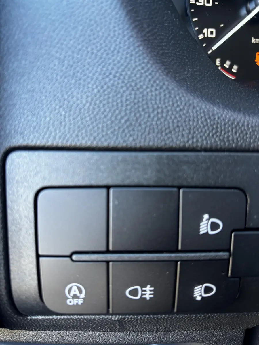 Gros plan sur les commandes d'éclairage et désactivation auto start-stop du tableau de bord du Peugeot Boxer Fourgon blanc.