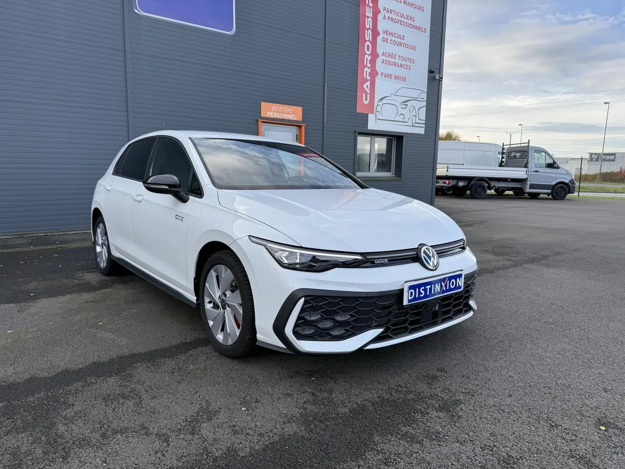 Volkswagen Golf 1.5 eHybrid blanc oryx nacré vue 3/4 avant avec calandre nid d'abeilles et jantes spécifiques GTE.