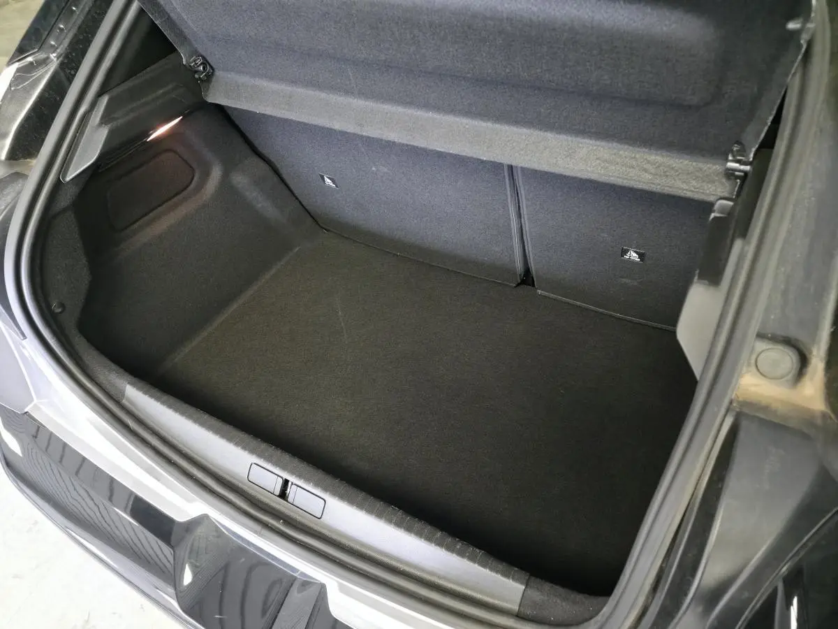 Coffre ouvert vu de dessus d'une Lancia Ypsilon 1.2 Ibrida gris métallisé avec intérieur noir.