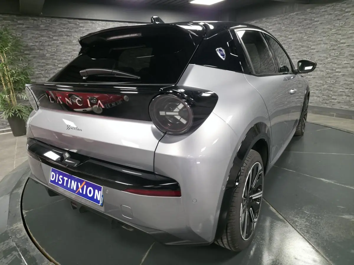 Vue 3/4 arrière droite de la Lancia Ypsilon 2025 gris bi-color avec toit noir et jantes alliage 17 pouces diamantées.