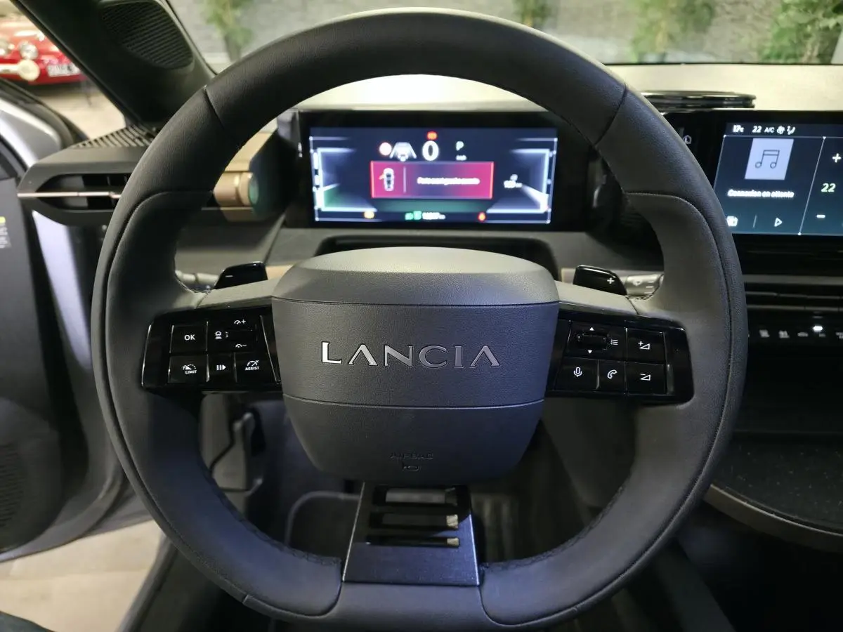 Volant sport Lancia Ypsilon 2025 vu de face, avec commandes intégrées et tableau de bord numérique lumineux.