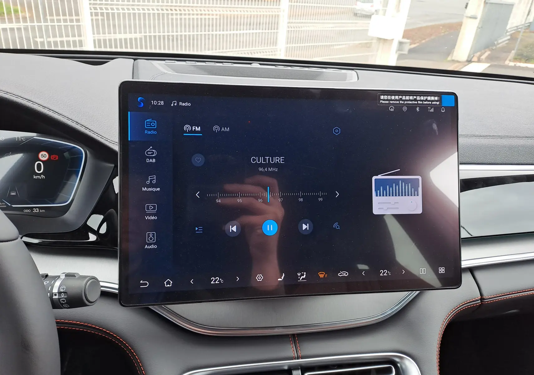 Vue intérieure frontale du tableau de bord BYD SEAL U 2025 avec écran tactile central 15,6'' et finitions noires avec surpiqûres orange.