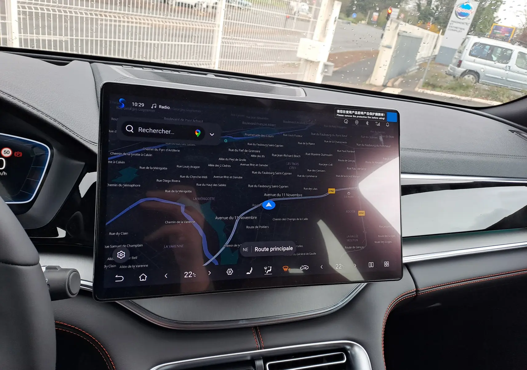 Vue intérieure centrée sur le volant noir et gris du BYD SEAL U 2025 avec tableau de bord numérique et écran tactile.