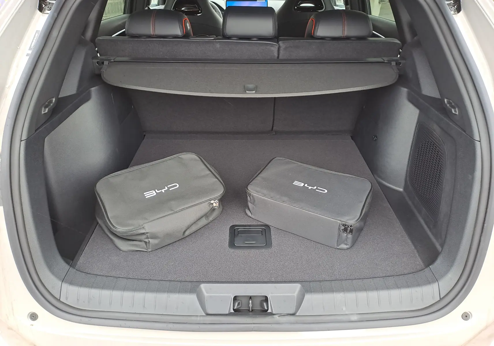 Gros plan sur le volant droit en cuir noir du BYD SEAL U 2025, avec commandes vocales et écran numérique en arrière-plan.