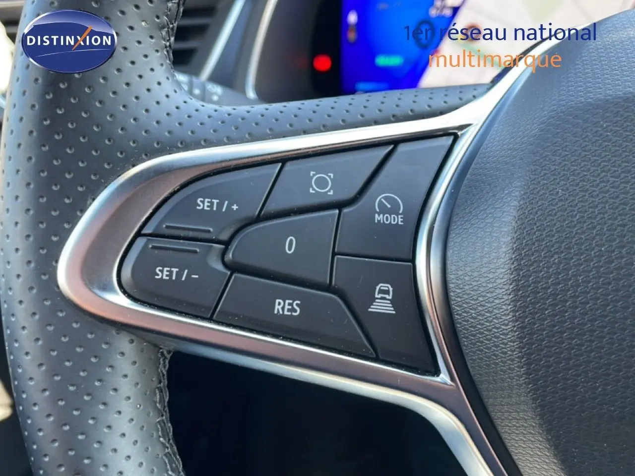 Gros plan sur les commandes de régulateur de vitesse au volant perforé noir du Renault Symbioz 2025 finition Iconic.