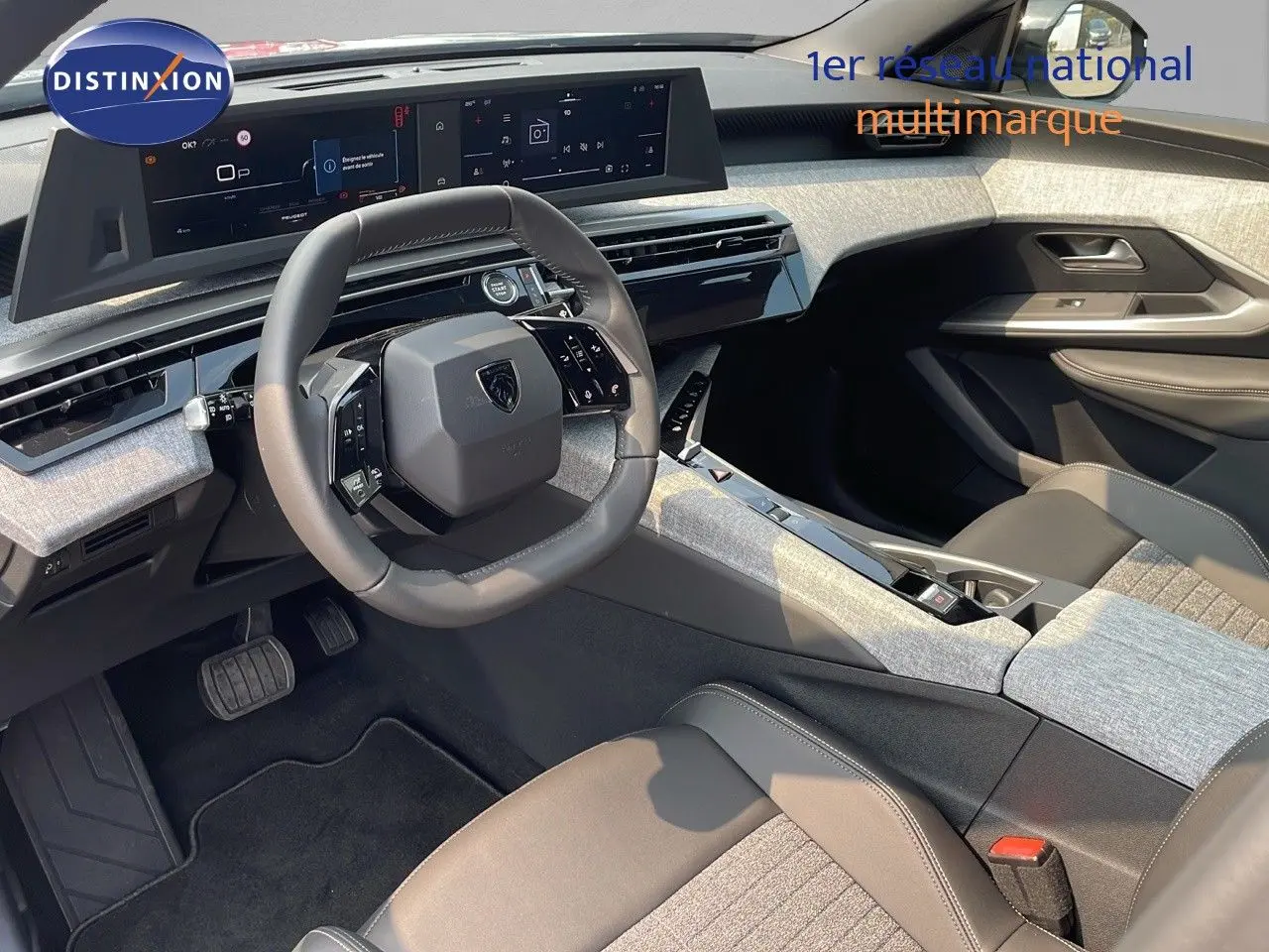 Intérieur du Peugeot 3008 2025 vu côté conducteur, tableau de bord moderne avec écran large et sellerie tissu cuir gris.