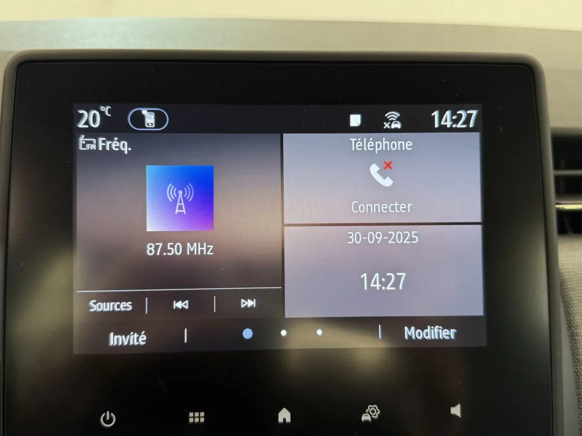 Écran tactile central de la Renault Clio noire 2025 affichant radio FM et menu téléphone à 14h27.