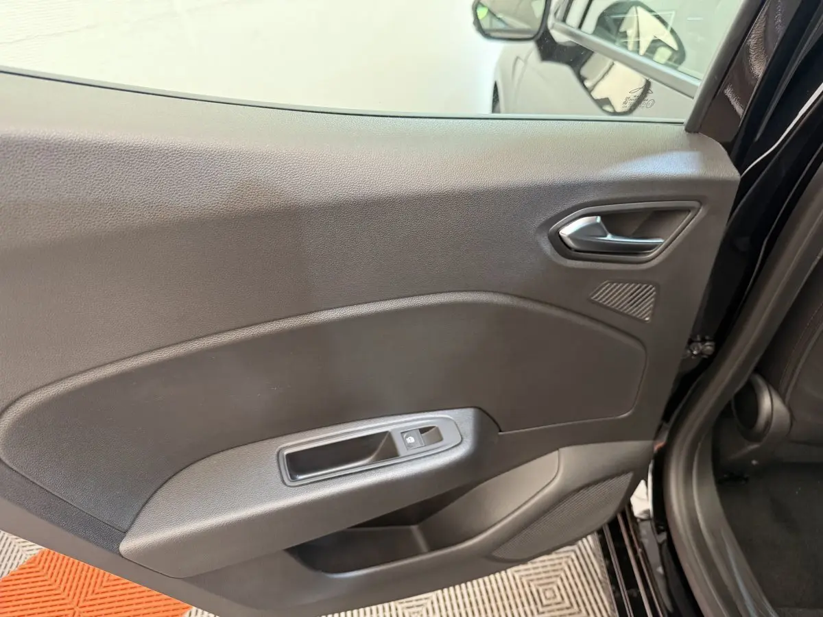Vue intérieure côté gauche de la porte arrière noire de la Renault Clio Evolution Blue dCi 100 avec commande de vitre électrique.