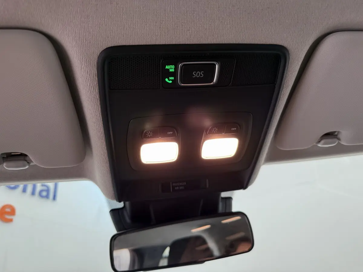 Plafonnier avec éclairage et bouton SOS dans l'habitacle clair d'une Renault Clio noire 2025 vue de l'intérieur avant.